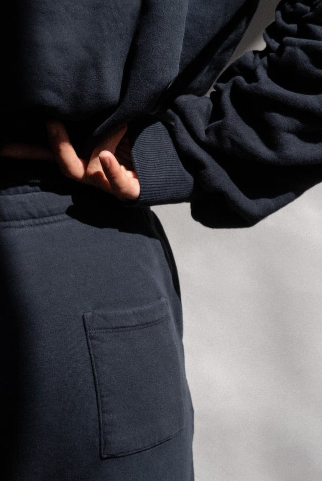 The Abby tapered sweatpants in navy on model, organic cotton fleece