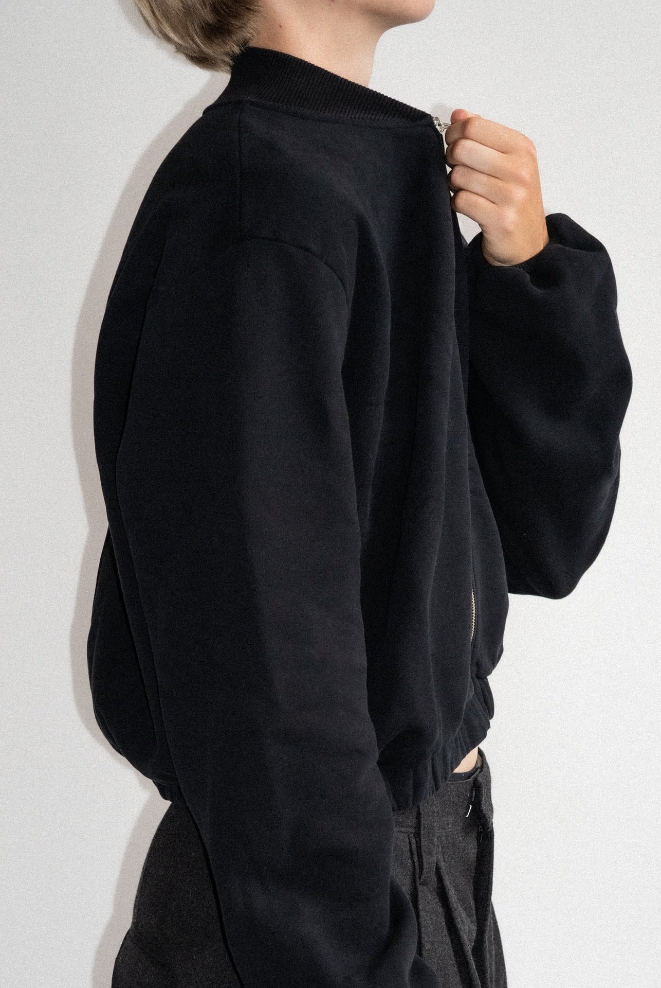 The Pippa bomber jacket in essential black on model, organic cotton fleece