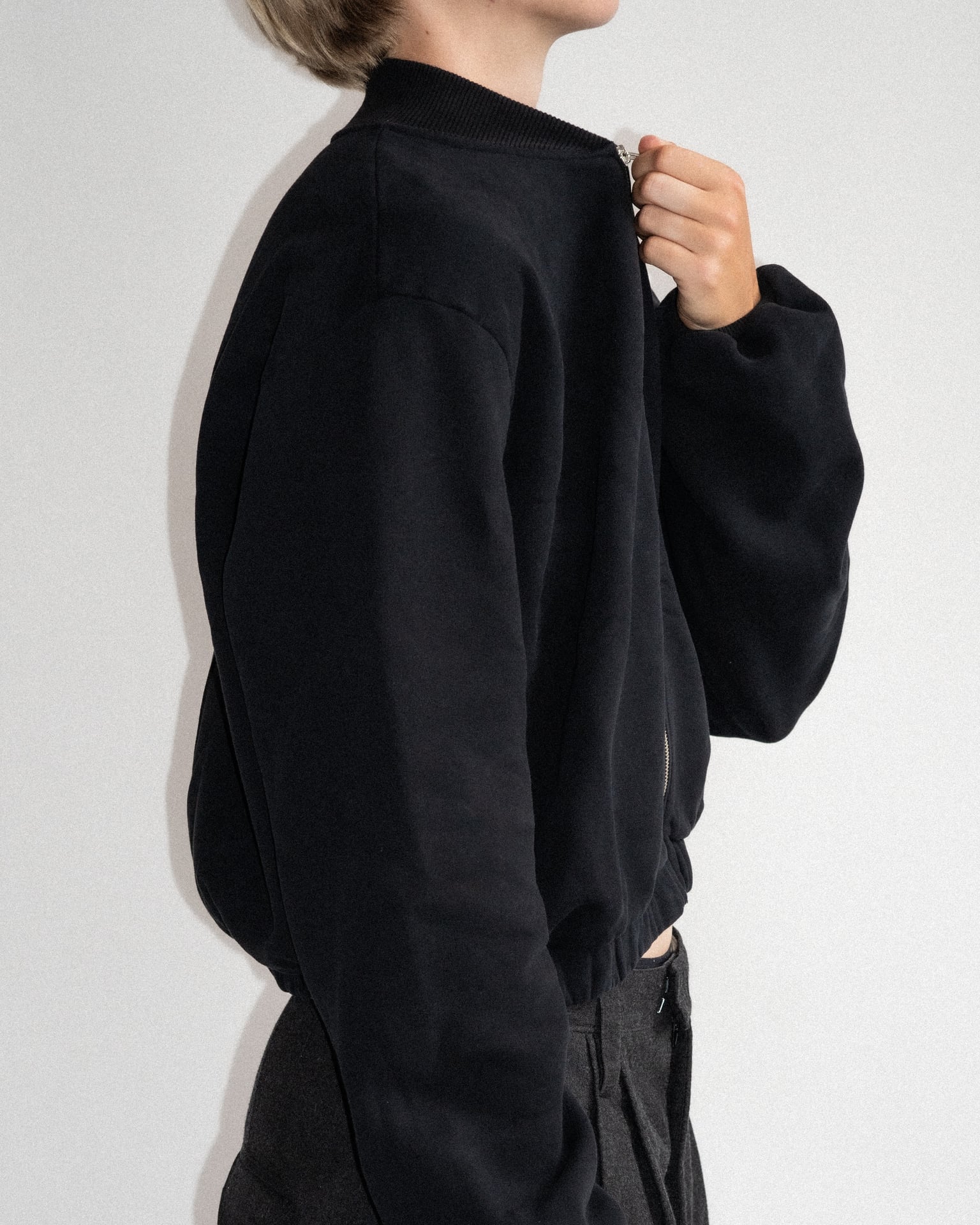 The Pippa bomber jacket in essential black on model, organic cotton fleece