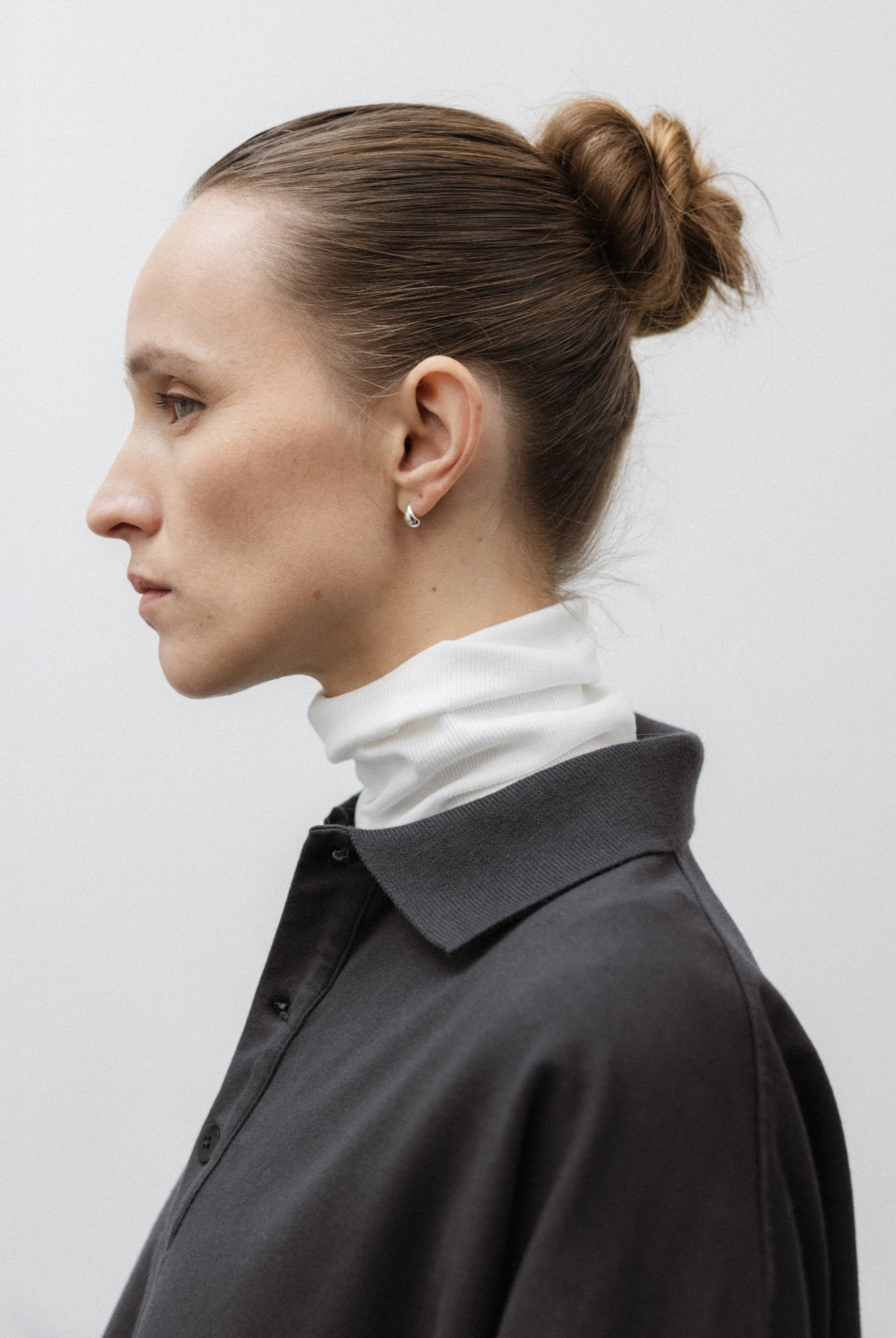The Theresa in Off-White. Ribbed Turtleneck. 95% organic cotton with 5% elastane. GOTS. Shown on model with The Remi in Pitch Black.