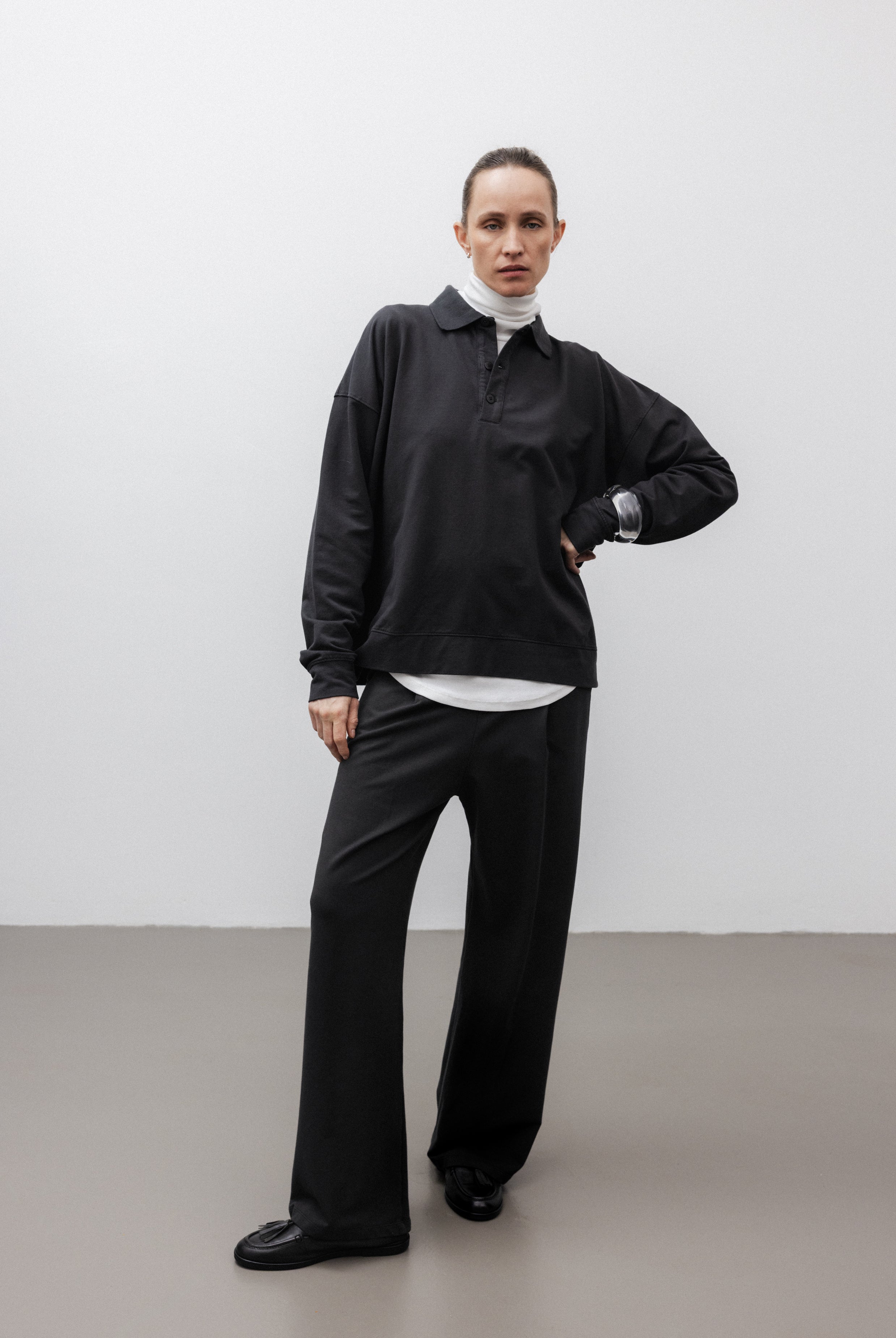 The Riley in Pitch Black. 100% organic cotton babyfleece. GOTS certified. Shown on model with The Theresa in Off-White & The Remi in Pitch Black.
