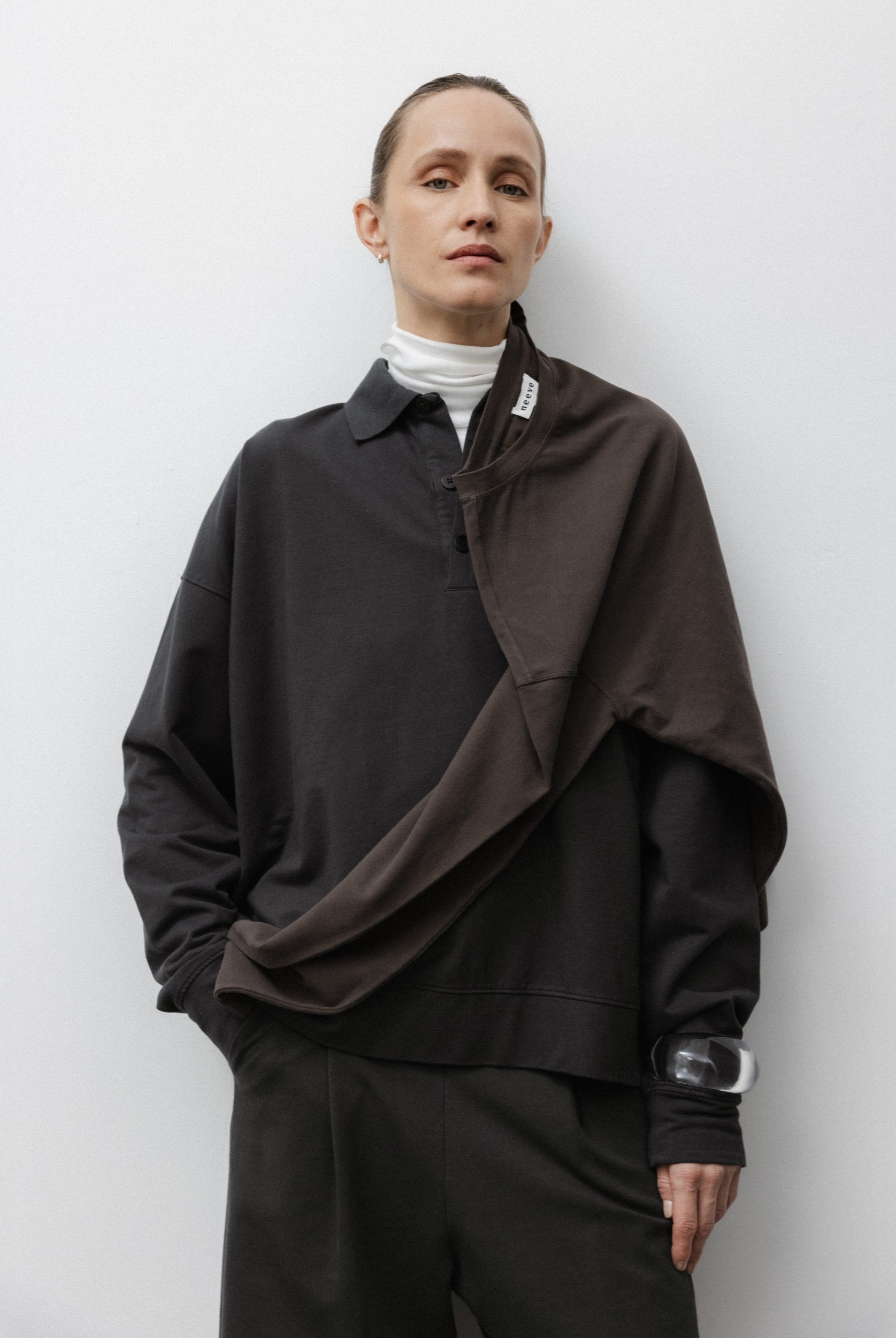 The Remi in Pitch Black. Polo long sleeve and a boxy shape. Made from 100% organic cotton babyfleece. GOTS. Shown on model with The Theressa in Off-White and The Rose in Chocolate.