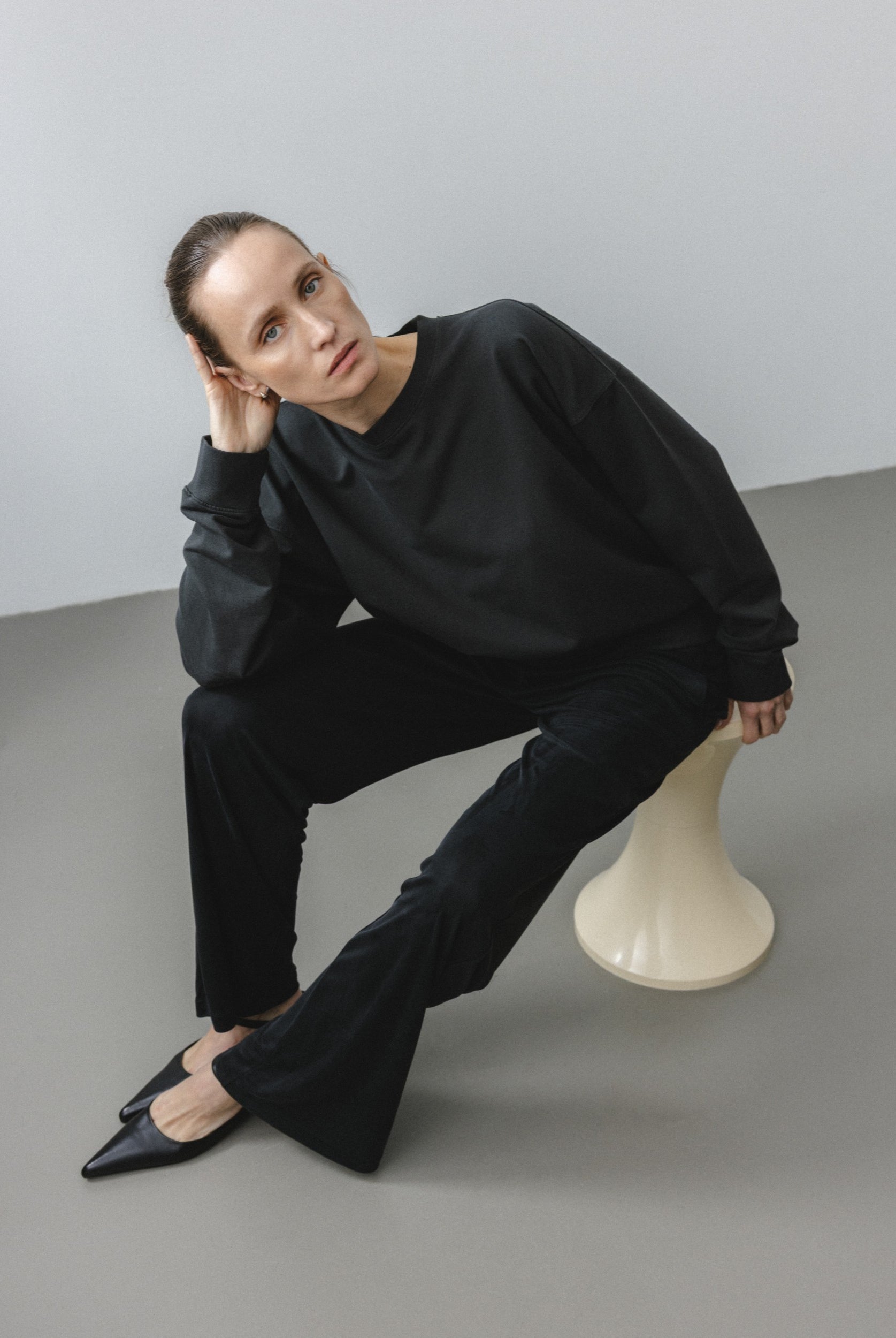The May in Pitch Black. Crew-neck sweater with a boxy shape. 100% organic cotton babyfleece. GOTS. Shown on model with The Sam in Essential Black.
