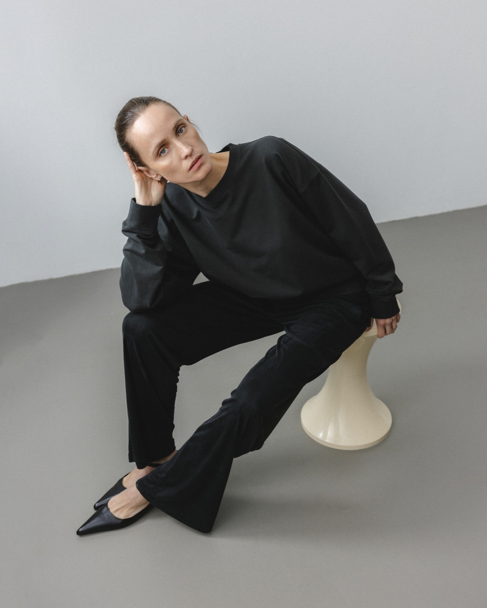The May in Pitch Black. Crew-neck sweater with a boxy shape. 100% organic cotton babyfleece. GOTS. Shown on model with The Sam in Essential Black.