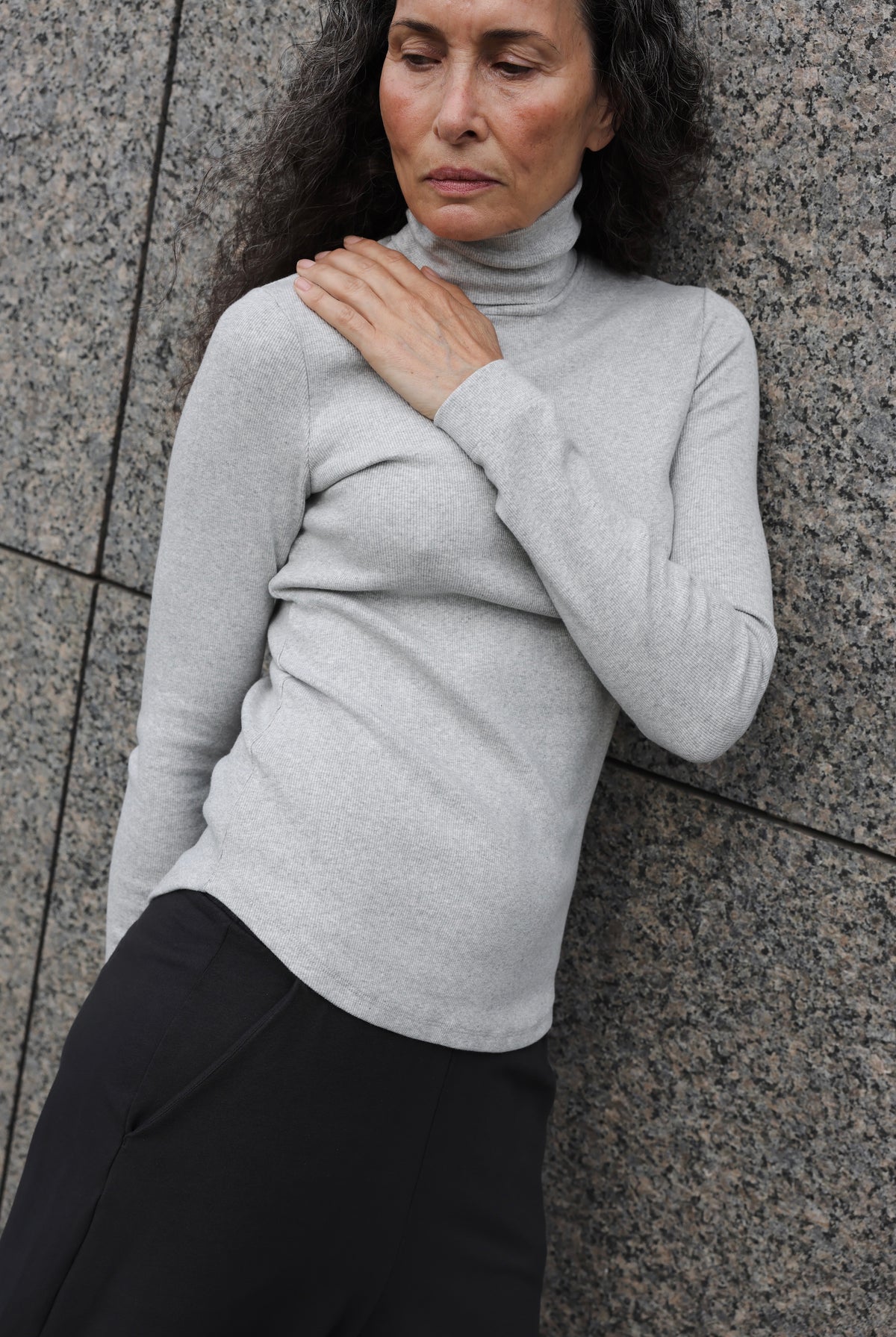 The Theresa in Grey Melange. A ribbed turtleneck cut from 95% organic cotton with 5% elastane. Shown on model.