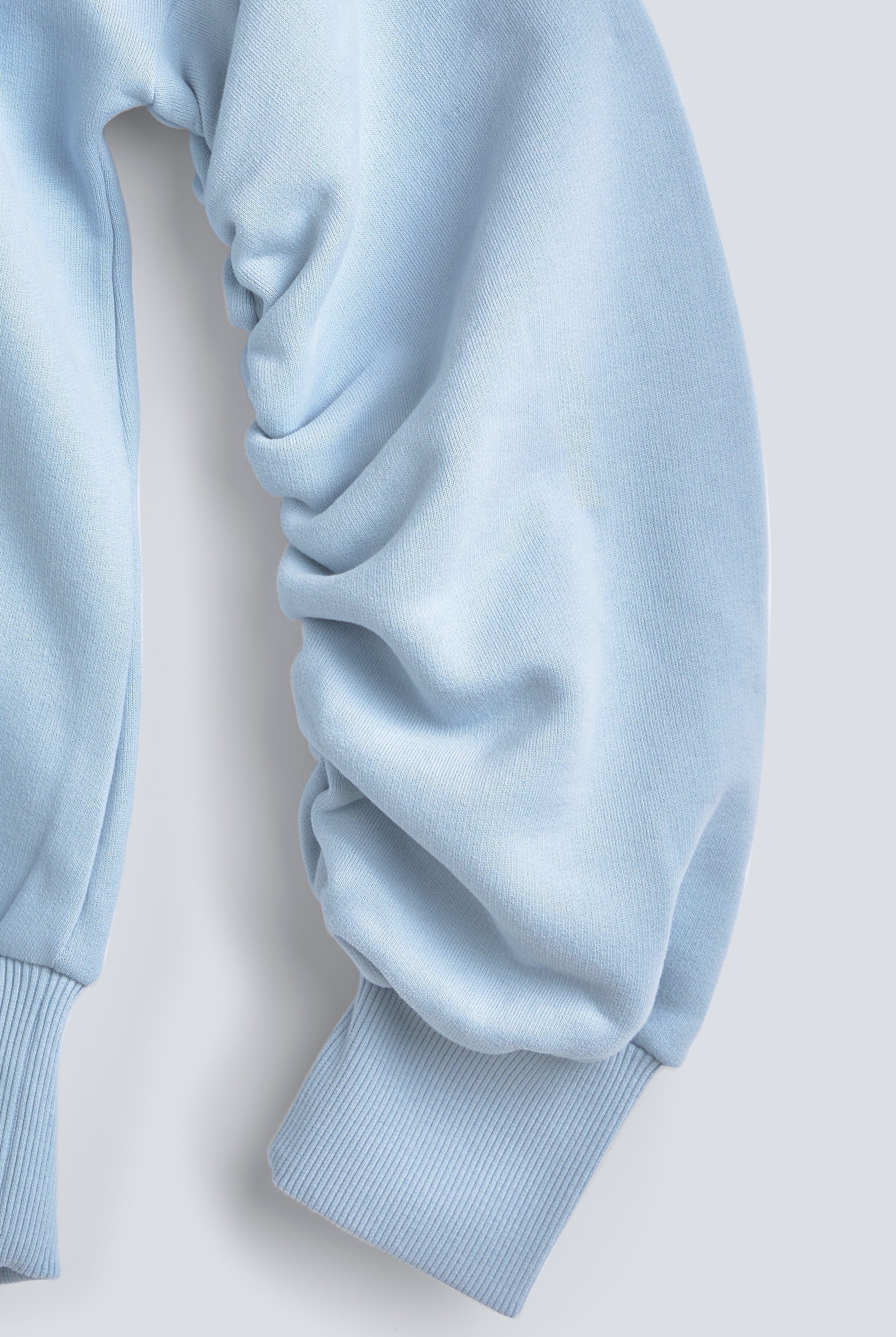 The Blake blue fog sweatshirt twisted sleeve detail, signature design feature