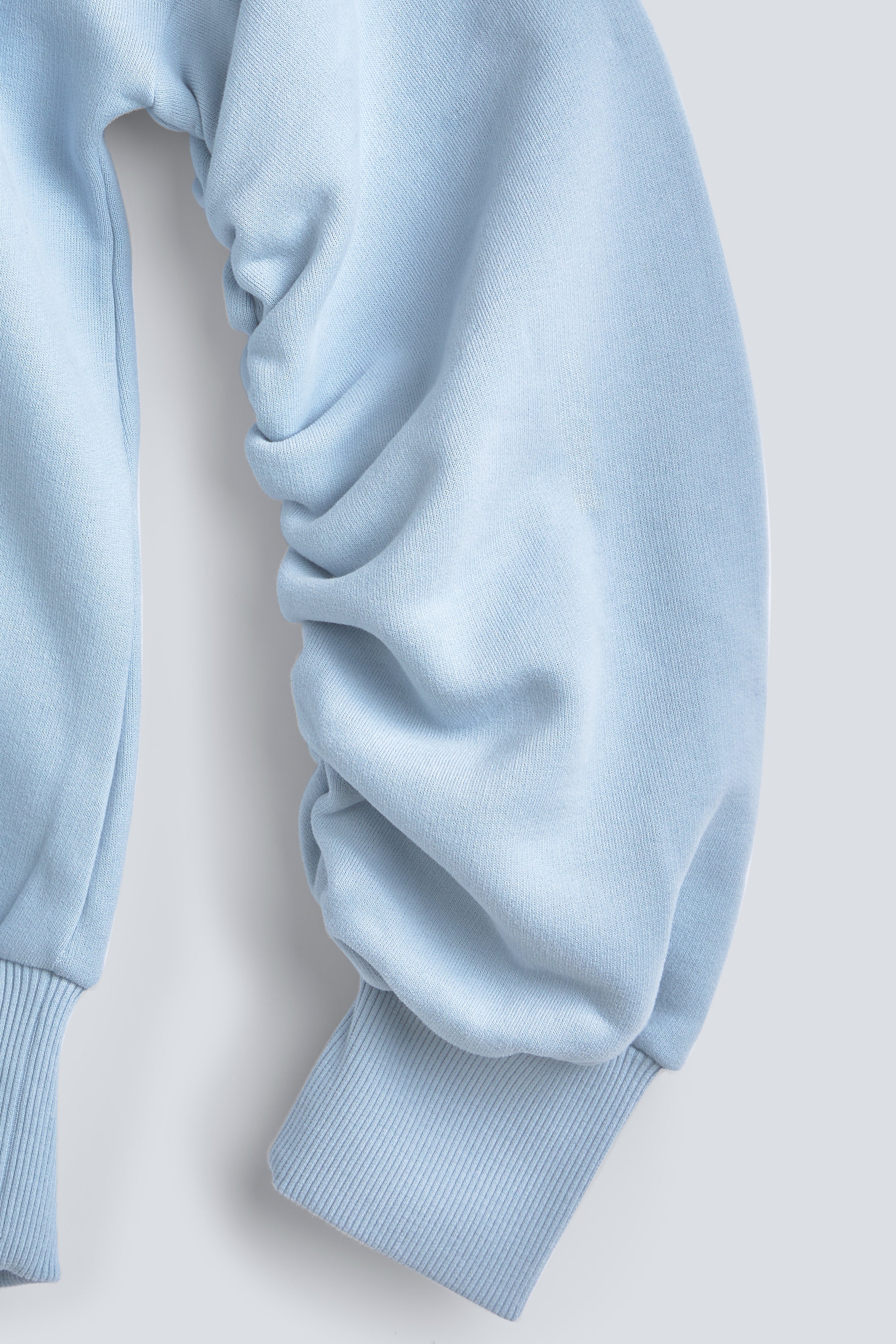 The Blake blue fog sweatshirt twisted sleeve detail, signature design feature