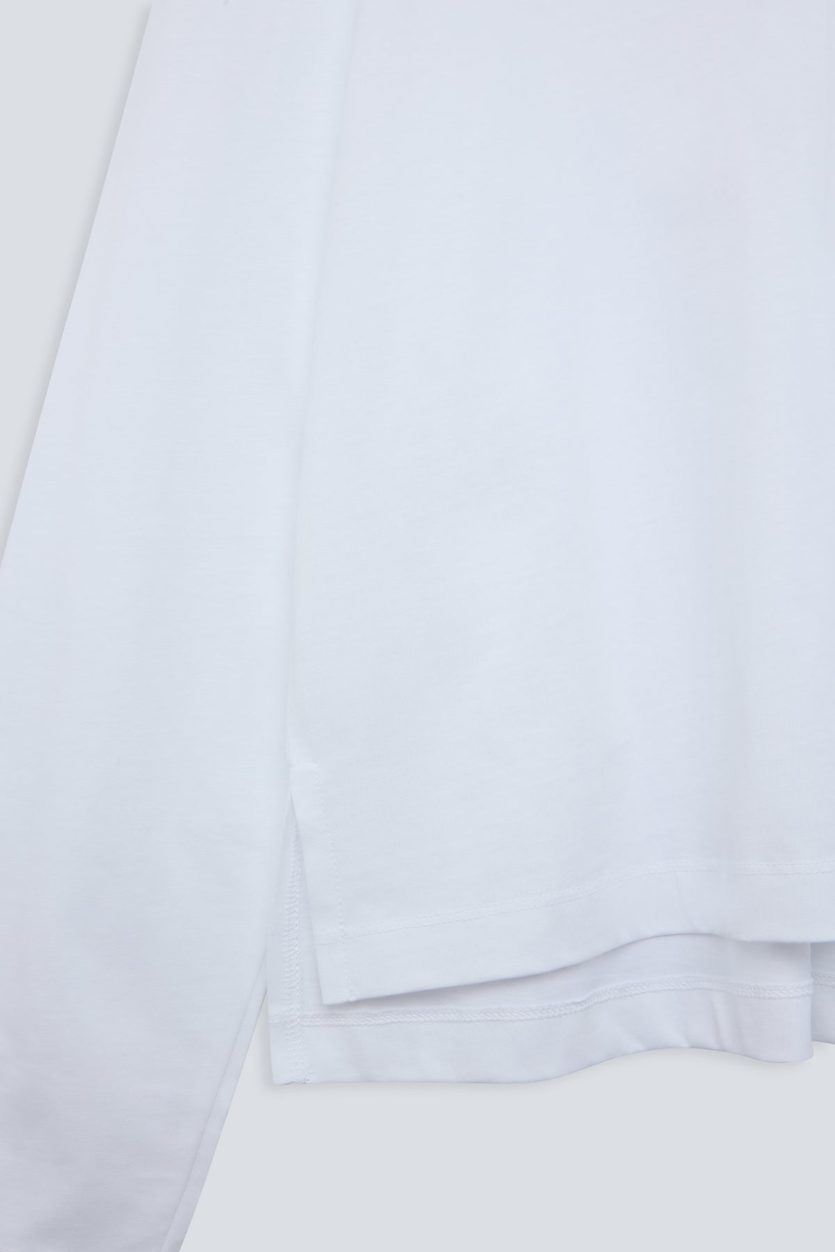 The Charlie in Crispy White. Polo long sleeve, 180 grams. 100% organic cotton. Hem detail.