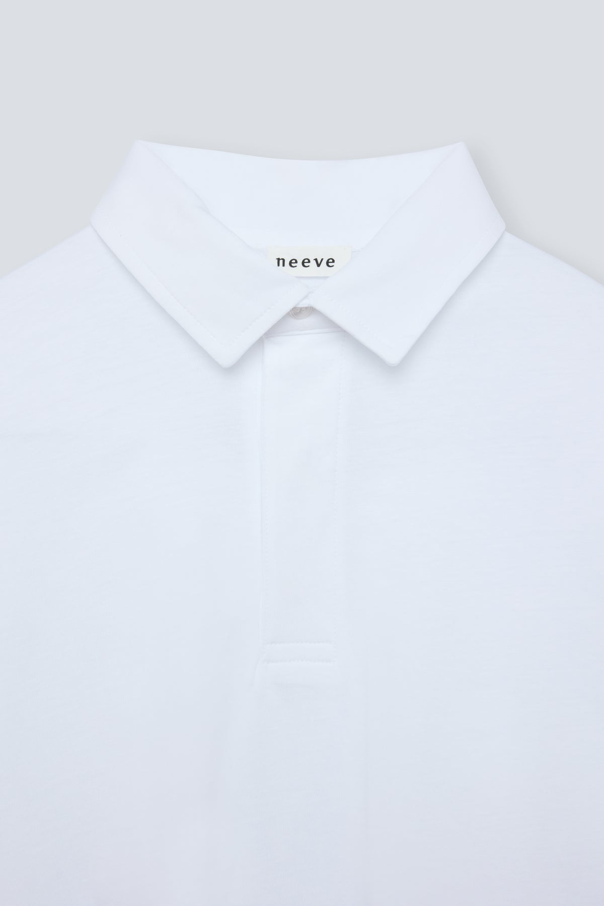 The Charlie in Crispy White. Polo long sleeve, 180 grams. 100% organic cotton. Collar detail. Front view.