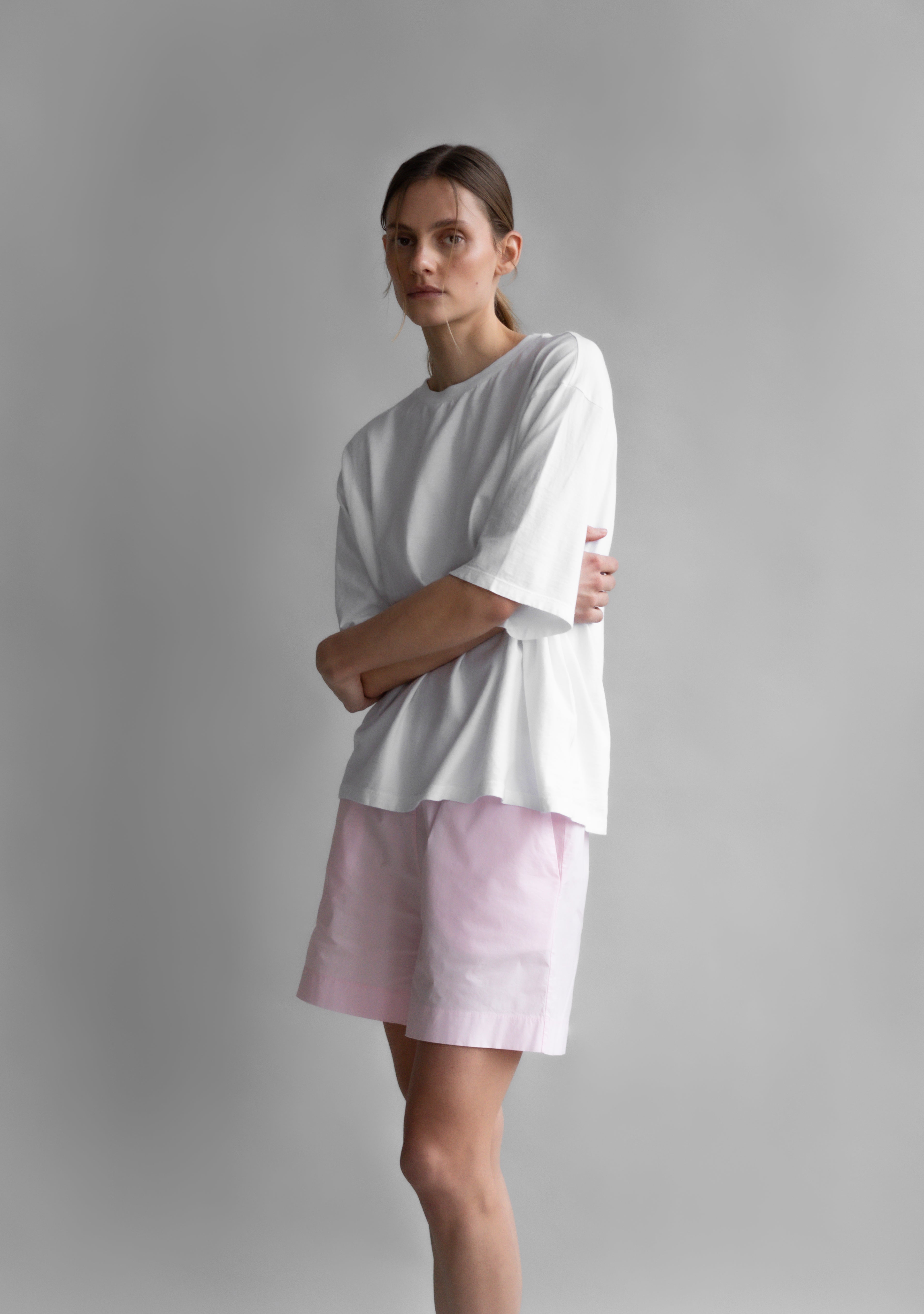 The Lara in Crispy White shown on model. 140 grams organic cotton. Shown with The Lux in Rose Pink. GOTS certified.