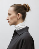 The Theresa in Off-White. Ribbed Turtleneck. 95% organic cotton with 5% elastane. GOTS. Shown on model with The Remi in Pitch Black. 