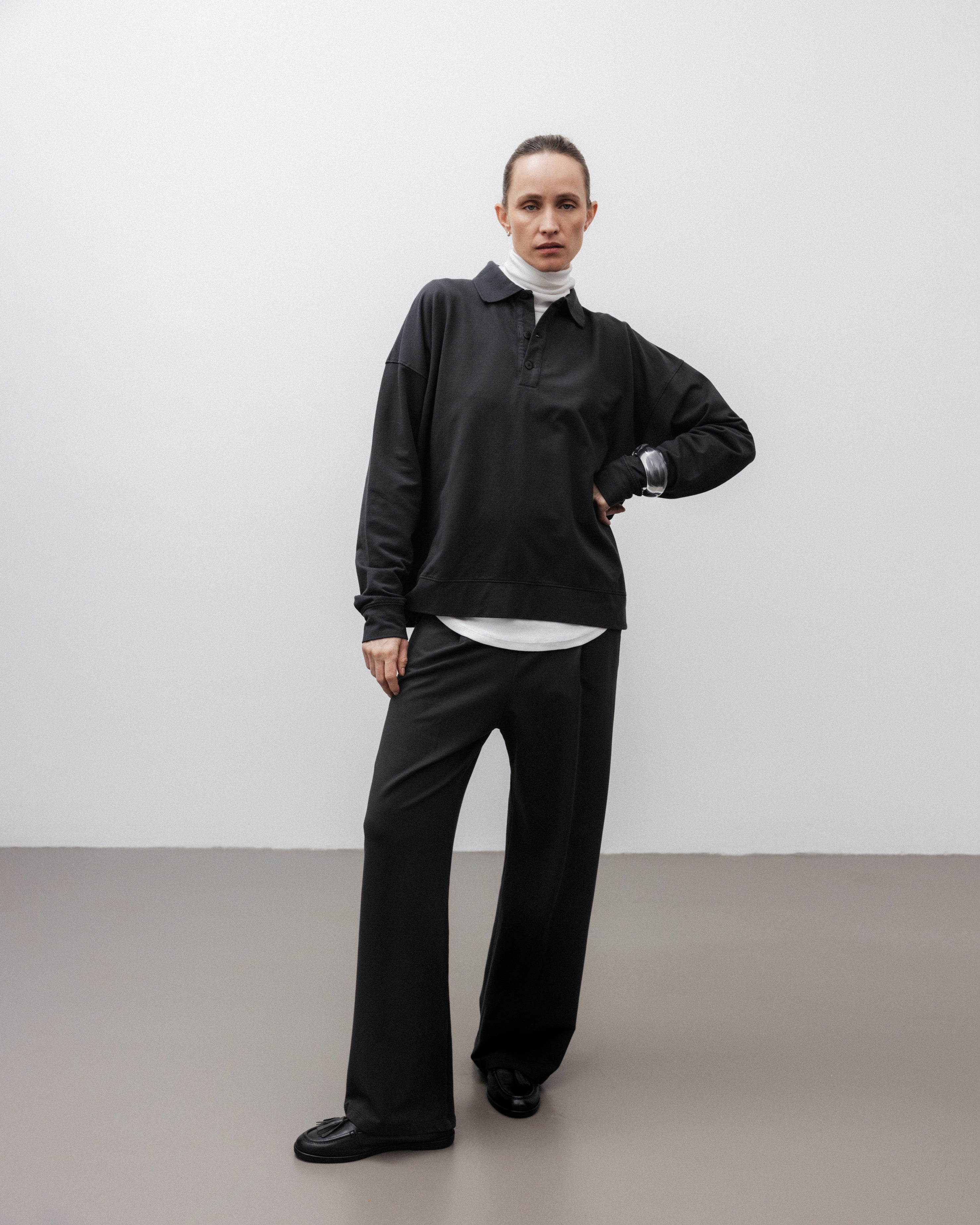 The Riley in Pitch Black. 100% organic cotton babyfleece. GOTS certified. Shown on model with The Theresa in Off-White & The Remi in Pitch Black. 