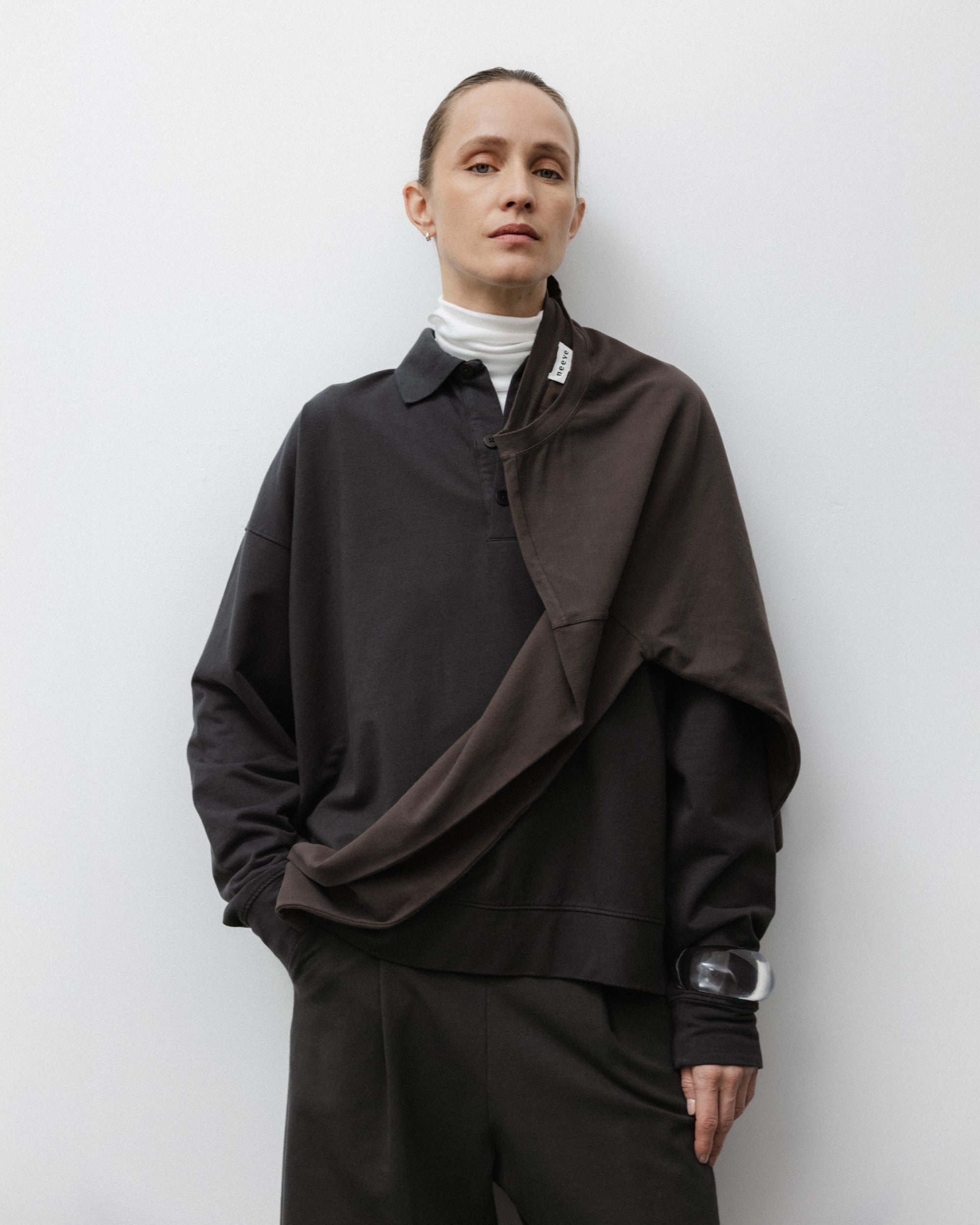 The Remi in Pitch Black. Polo long sleeve and a boxy shape.  Made from 100% organic cotton babyfleece. GOTS. Shown on model with The Theressa in Off-White and The Rose in Chocolate. 