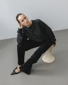 The May in Pitch Black. Crew-neck sweater with a boxy shape. 100% organic cotton babyfleece. GOTS. Shown on model with The Sam in Essential Black. 