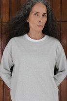 The Rose in Grey Melange. An oversized long sleeve that wears like a sweater, but lighter. 95% organic cotton with 5% elastane. Shown on model together with The Michelle in Crispy White.