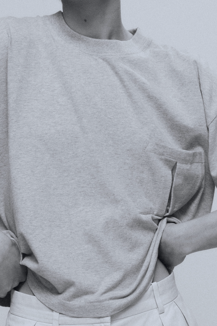 The Tess grey melange tee detail view on model, dropped shoulders