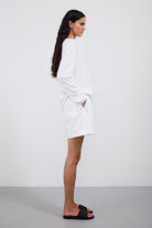 The Emily longsleeve in crispy white shown on model with The Lux shorts in poplin cotton. 