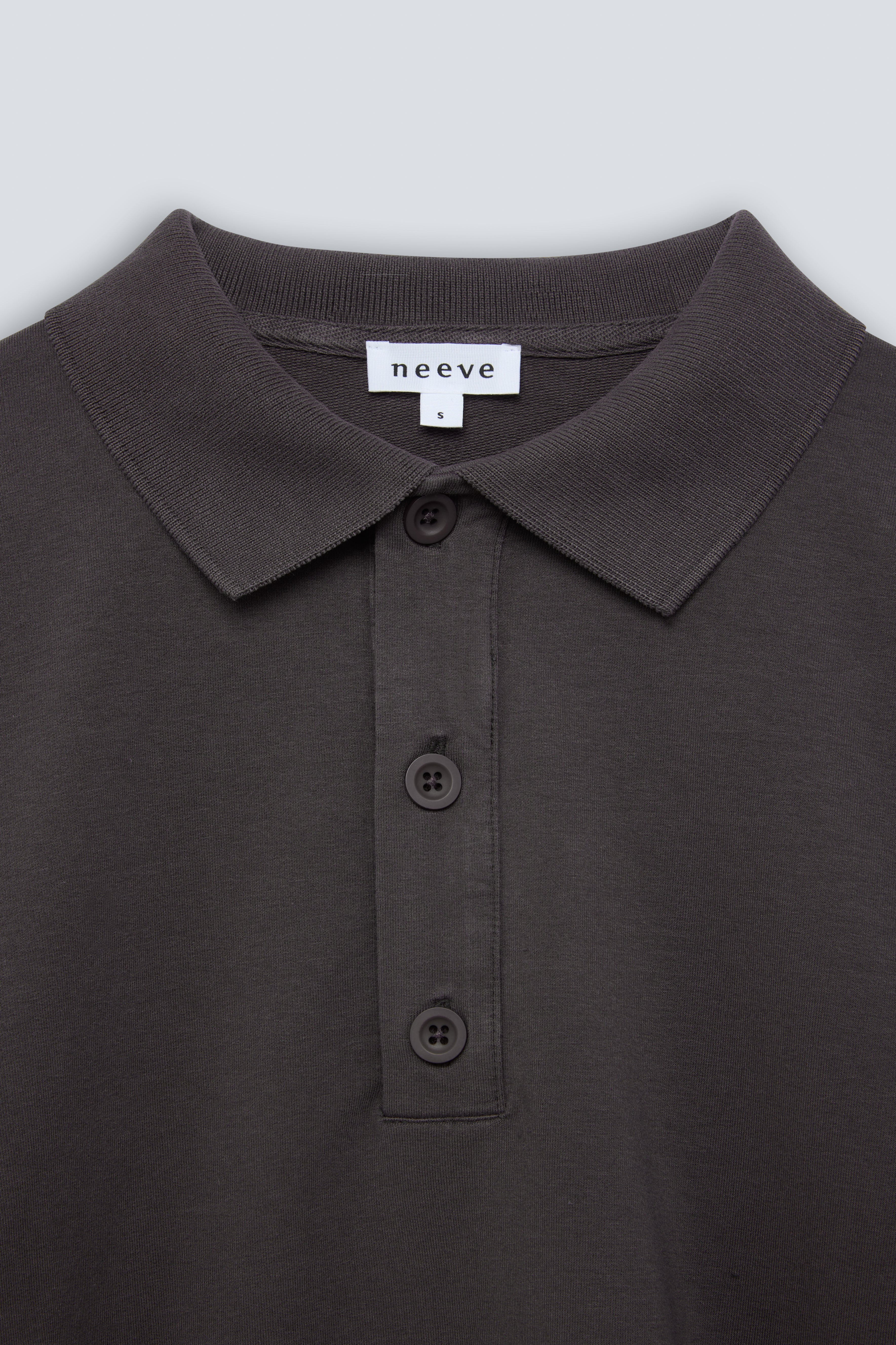 The Remi in Pitch Black. Polo long sleeve and a boxy shape.  Made from 100% organic cotton babyfleece. GOTS. Collar detail. 
