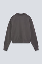 The Remi in Pitch Black. Polo long sleeve and a boxy shape.  Made from 100% organic cotton babyfleece. GOTS. Back View. 