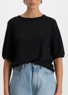 The Billie linen top in essential black on model, mid-sleeve crew neck, 100% linen made in Portugal